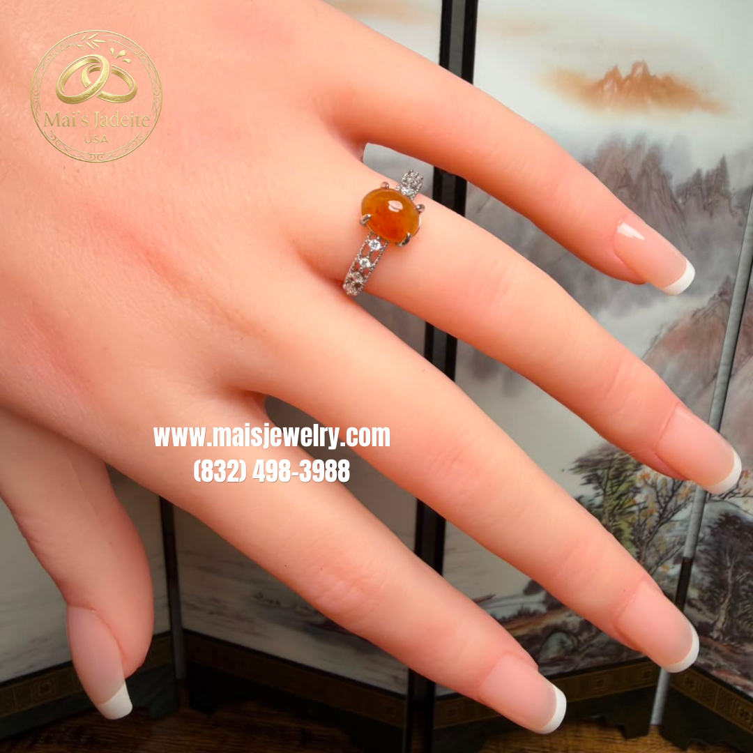Two Silver Jadeite Jade Rings featuring a translucent green Type A Burmese jadeite cabochon and a vibrant honey-orange jadeite cabochon on a white marble display.