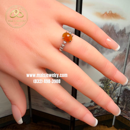 Two Silver Jadeite Jade Rings featuring a translucent green Type A Burmese jadeite cabochon and a vibrant honey-orange jadeite cabochon on a white marble display.